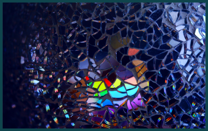 Photo of broken glass, some reflecting various colours (via Pexels)