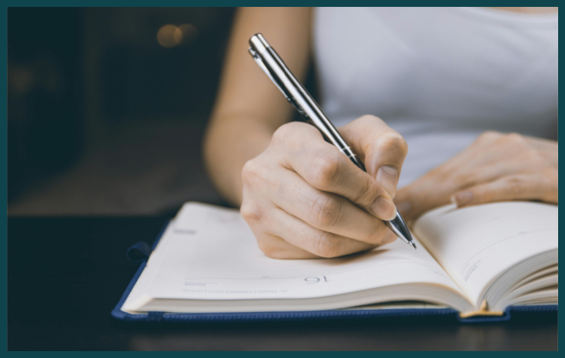 Photo of woman writing with a pen in a journal by JESHOOTS.com via Pexels.